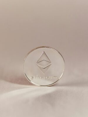 A silver Ethereum coin standing upright, symbolizing cryptocurrency and modern finance.