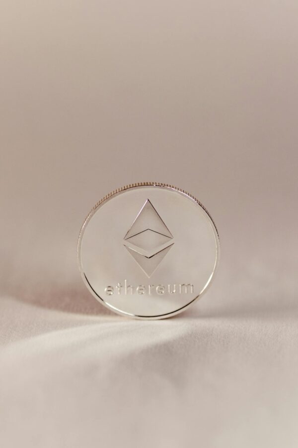 A silver Ethereum coin standing upright, symbolizing cryptocurrency and modern finance.